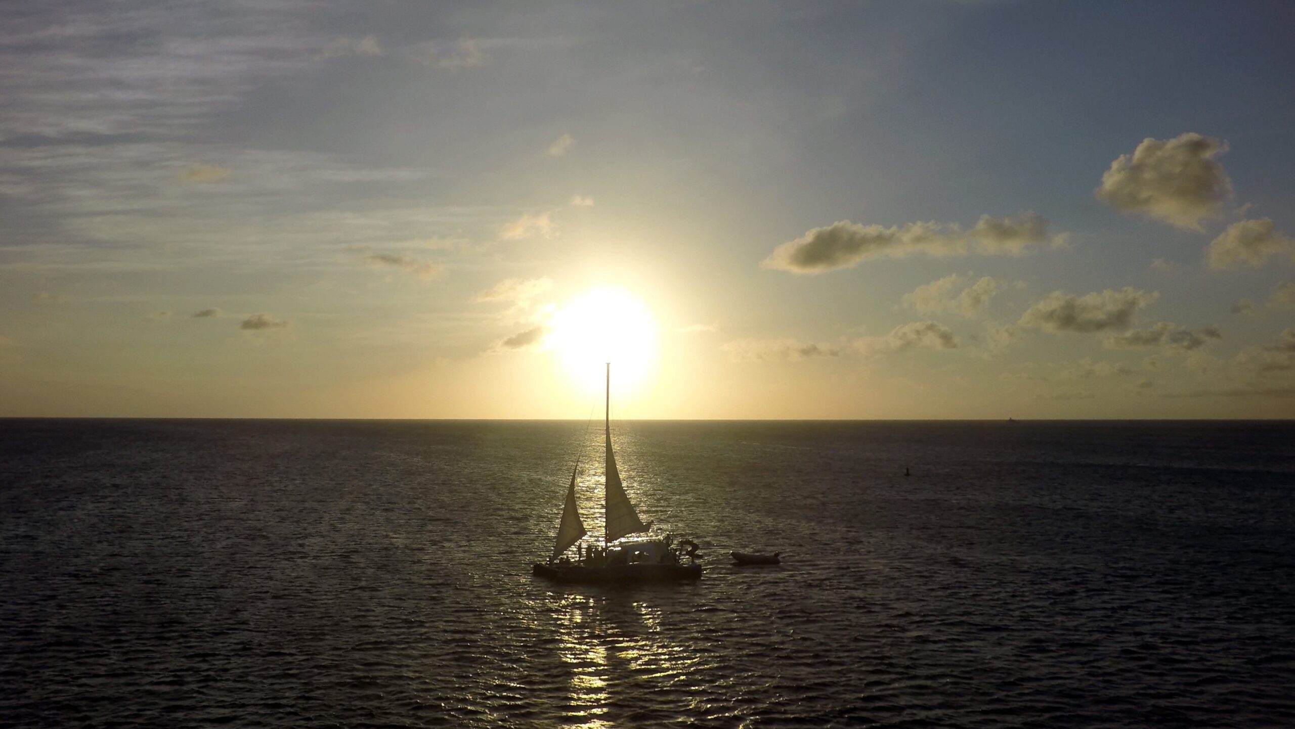 Sailboat out on the sea at sunset, water around it